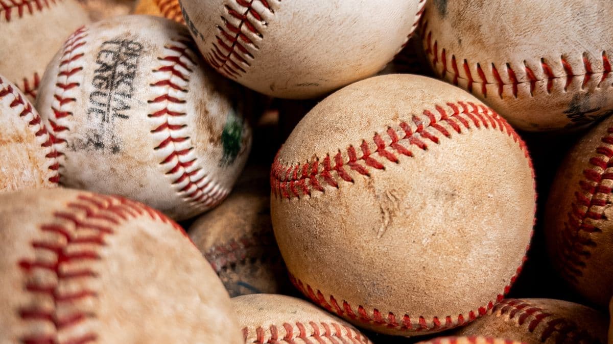 Varias pelotas de béisbol de cuero gastadas amontonadas